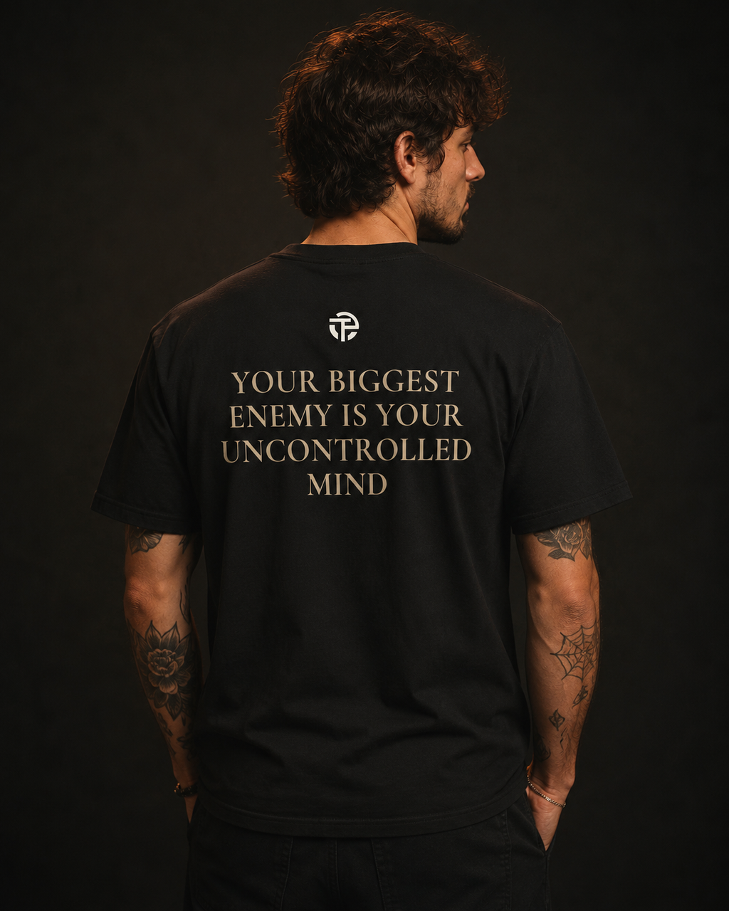Model wearing the TPC Uncontrolled Mind black tee, back view with the 'uncontrolled mind' quote