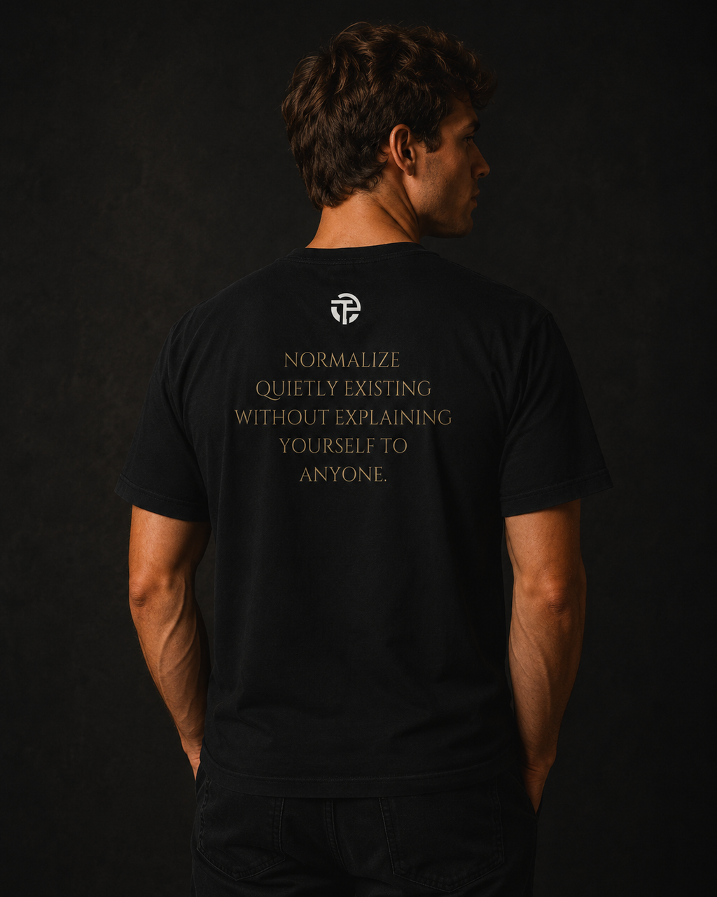 Model wearing the TPC Quietly Existing Variant B black tee, back view with the quote