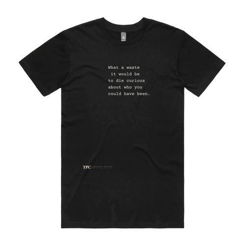 What A Waste black t-shirt front — TPC tee with the typed line 'What a waste it would be to die curious about who you could have been'